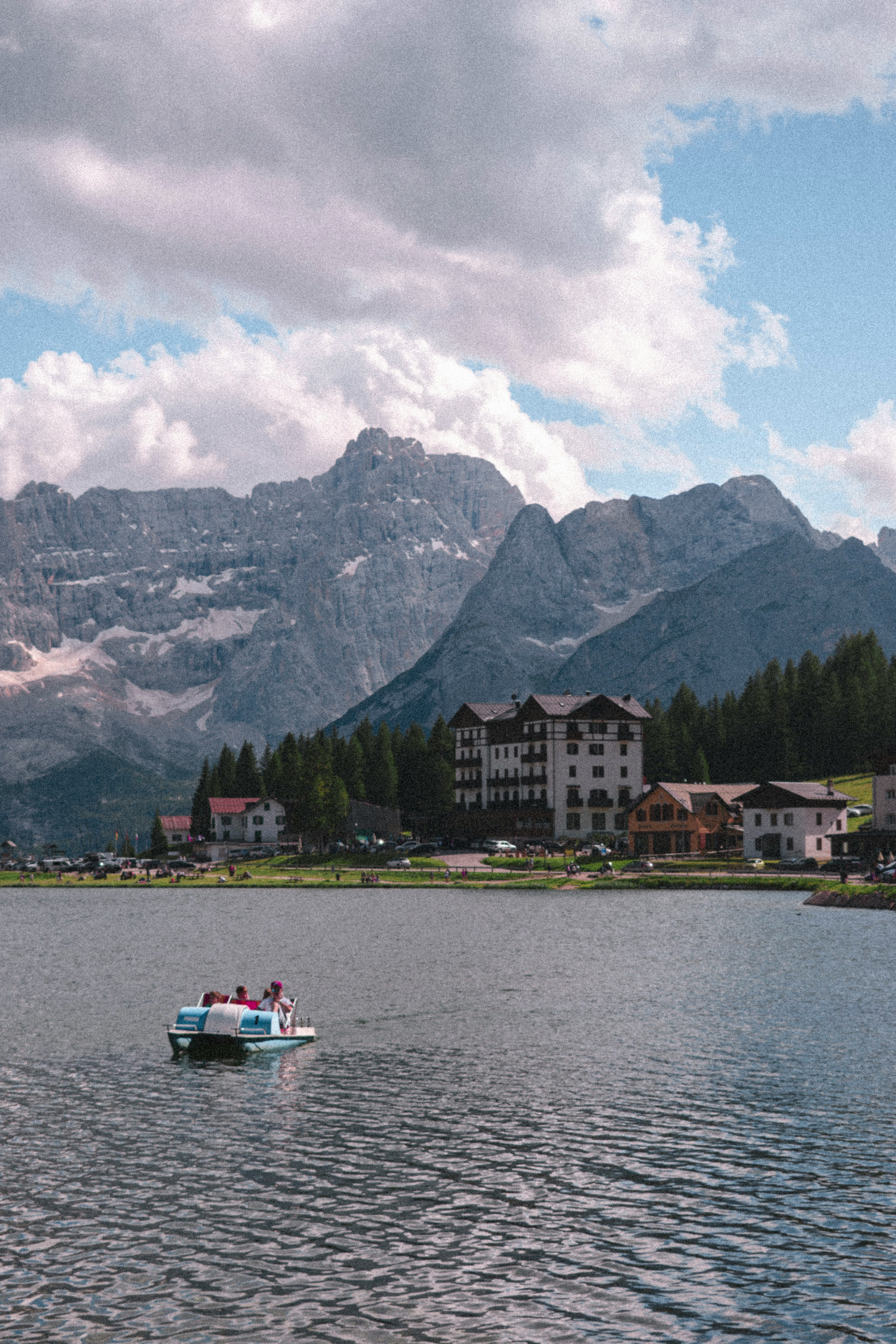 white boat on water near green trees and buildings during daytime